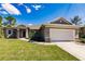 Charming single-story home featuring a well-manicured lawn and two-car garage at 7354 Helliwell St, North Port, FL 34291