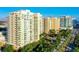 Aerial view of luxurious high-rise apartments with private balconies overlooking a scenic park and waterfront at 800 N Tamiami Trl # 312, Sarasota, FL 34236