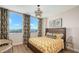 Bedroom with large window, stylish curtains, modern light fixture, and wooden bed frame at 800 N Tamiami Trl # 312, Sarasota, FL 34236