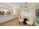 Open-concept dining area with a glass table and chairs, flowing seamlessly into the kitchen space at 800 N Tamiami Trl # 312, Sarasota, FL 34236