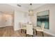 Bright dining area featuring a modern chandelier and artwork, adjacent to the entry door at 800 N Tamiami Trl # 312, Sarasota, FL 34236