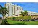 The building's exterior shows mature landscaping, and ample parking, set against a bright blue sky at 800 N Tamiami Trl # 312, Sarasota, FL 34236