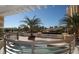 An expansive outdoor terrace with a water feature, potted palm trees, and a white pergola offering city views at 800 N Tamiami Trl # 312, Sarasota, FL 34236