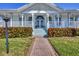 Inviting front porch with classic white columns and steps, framed by lush landscaping and brick pathway at 8012 18Th W Ave, Bradenton, FL 34209