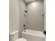 Bathroom with a shower/tub combo, gray tile, and black fixtures at 8046 Anthirium Loop, Sarasota, FL 34240