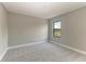 Well-lit bedroom featuring a large window with neighborhood views and plush carpet at 8046 Anthirium Loop, Sarasota, FL 34240