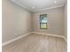 Bright bedroom features a window, wood-look tile floors, and neutral walls at 8046 Anthirium Loop, Sarasota, FL 34240