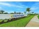 Windward community entrance sign with lush landscaping and palm trees under a blue sky at 8046 Anthirium Loop, Sarasota, FL 34240