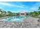 Community pool with palm trees, lounge chairs, and a beautiful clubhouse at 8046 Anthirium Loop, Sarasota, FL 34240