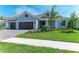 Attractive single-story home featuring a three-car garage, stone accents, and a well-maintained lawn at 8046 Anthirium Loop, Sarasota, FL 34240