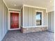 Inviting covered front porch with brick accents, providing a welcoming entryway to the home at 8046 Anthirium Loop, Sarasota, FL 34240
