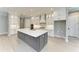 Spacious kitchen featuring a gray island, white cabinets, stainless steel appliances, and ample counter space at 8046 Anthirium Loop, Sarasota, FL 34240