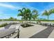 A charming outdoor patio with tables and chairs, surrounded by tropical palm trees and manicured landscaping at 8046 Anthirium Loop, Sarasota, FL 34240