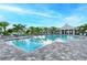A beautiful community pool with lounge chairs and palm trees under a bright, sunny sky at 8046 Anthirium Loop, Sarasota, FL 34240