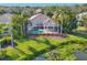 Aerial home view featuring a private pool, screened lanai, and meticulously landscaped grounds with a pond at 8330 Abingdon Ct, University Park, FL 34201