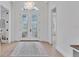 Bright foyer featuring decorative glass doors, beautiful chandelier, light floors, and an elegant area rug at 8330 Abingdon Ct, University Park, FL 34201