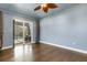 Bedroom with ceiling fan, wood floors, and sliding doors to the outdoor patio at 8420 Sailing Loop, Lakewood Ranch, FL 34202