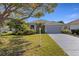 Charming single-story home with a well-manicured lawn and mature landscaping, including a palm tree at 8420 Sailing Loop, Lakewood Ranch, FL 34202