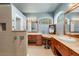 Stylish main bathroom featuring dual vanities and a vanity with arched windows for natural light at 8420 Sailing Loop, Lakewood Ranch, FL 34202