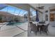 A covered patio provides outdoor dining with a view of the screened pool at 8420 Sailing Loop, Lakewood Ranch, FL 34202