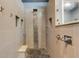 Modern shower with rain showerhead, pebble floor, and stone accents at 8420 Sailing Loop, Lakewood Ranch, FL 34202