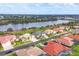 Wide aerial view showcasing a waterfront community with houses lining a lake, surrounded by lush greenery at 854 Dahoon Cir, Venice, FL 34293