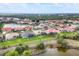 Wide aerial view of a community of houses surrounding a lake, surrounded by lush greenery and scenic landscapes at 854 Dahoon Cir, Venice, FL 34293