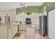 Well-lit kitchen with white cabinets, a central island, and stainless steel appliances offering an efficient cooking space at 854 Dahoon Cir, Venice, FL 34293