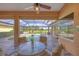 Covered lanai with a ceiling fan, overlooking a pool, spa, and fenced yard at 854 Dahoon Cir, Venice, FL 34293