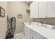 Laundry room features modern appliances, ample storage, and a convenient utility sink at 854 Dahoon Cir, Venice, FL 34293