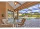 Covered patio with comfortable seating, overlooking a screened-in pool and lush backyard at 854 Dahoon Cir, Venice, FL 34293