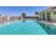 Large clear blue community pool surrounded by a tiled deck, lounge chairs, and a covered pavilion at 854 Dahoon Cir, Venice, FL 34293