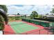 Aerial view of well-maintained tennis courts with lush landscaping and benches overlooking the courts at 854 Dahoon Cir, Venice, FL 34293