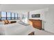 Bedroom featuring a woven bed frame, a dresser, and a wall of windows overlooking the water at 97 Sunset Dr # 202, Sarasota, FL 34236