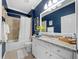 Stylish bathroom featuring blue walls, a granite countertop, and a bathtub with shower at 12151 Amica Loop, Venice, FL 34293