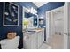 Bathroom features a white vanity with granite countertop and a decorative, vibrant blue painted wall at 12151 Amica Loop, Venice, FL 34293