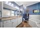 Elegant bathroom featuring a double vanity, a luxurious soaking tub, and a glass-enclosed shower at 12151 Amica Loop, Venice, FL 34293