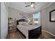 Serene bedroom with a black bed frame, stylish decor, and warm, inviting wood-look floors at 12151 Amica Loop, Venice, FL 34293