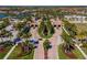 Aerial view of a grand entrance to a community, featuring lush landscaping and palm-lined avenues at 12151 Amica Loop, Venice, FL 34293