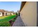 Beautiful exterior featuring lush landscaping and a charming brick pathway leading to the home's entrance at 12151 Amica Loop, Venice, FL 34293