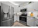 Bright kitchen with white cabinets, stainless steel appliances, and granite counters at 12151 Amica Loop, Venice, FL 34293