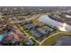 Aerial view of multiple tennis courts and community center near a lake at 12151 Amica Loop, Venice, FL 34293