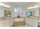 A Primary bathroom featuring dual sinks, a standalone tub, and decorative lighting at 12263 Lavender Loop, Bradenton, FL 34212