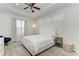 Inviting bedroom with neutral tones, a white bedspread, a ceiling fan and wood look flooring at 12263 Lavender Loop, Bradenton, FL 34212