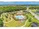 Aerial view of a community pool and playground surrounded by lush landscaping and walking trails at 12263 Lavender Loop, Bradenton, FL 34212