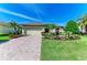Charming home featuring lush landscaping, a brick driveway, and a well-maintained lawn at 12263 Lavender Loop, Bradenton, FL 34212