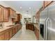 A long beautiful kitchen featuring stainless steel appliances and light colored tile flooring at 12263 Lavender Loop, Bradenton, FL 34212
