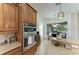 Gourmet kitchen with stainless steel appliances and granite countertops, connected to an open dining area at 12263 Lavender Loop, Bradenton, FL 34212