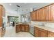 Open concept kitchen with stainless steel dishwasher and sink, beautiful wood cabinets and modern lighting at 12263 Lavender Loop, Bradenton, FL 34212