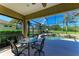 Screened lanai with a table and chairs overlooking a sparkling pool, lush greenery, and a serene pond view at 12263 Lavender Loop, Bradenton, FL 34212